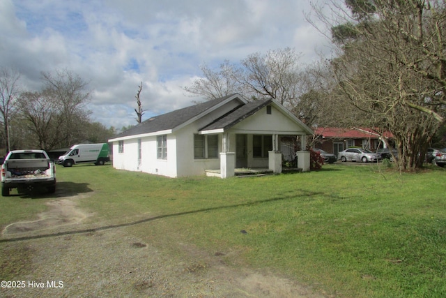 view of front facade featuring a shingled roof, stucco siding, and a front yard