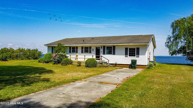 ranch-style house featuring roof with shingles and a front lawn