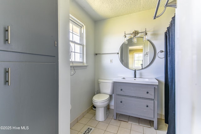 full bathroom featuring a textured ceiling, tile patterned floors, baseboards, vanity, and toilet