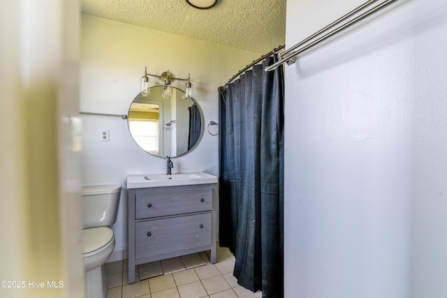 bathroom with a textured ceiling, tile patterned floors, toilet, and vanity