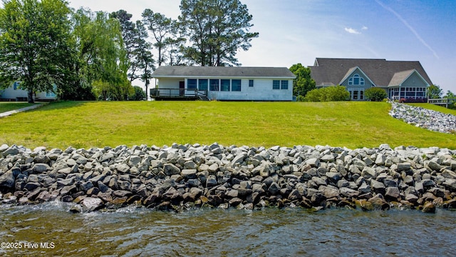 back of house featuring a yard and a deck with water view