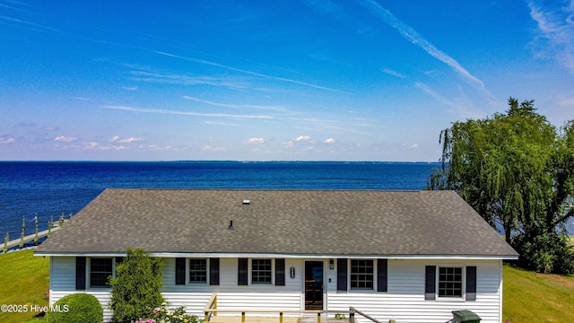 view of front facade with roof with shingles and a water view