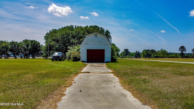 view of barn featuring a yard and driveway