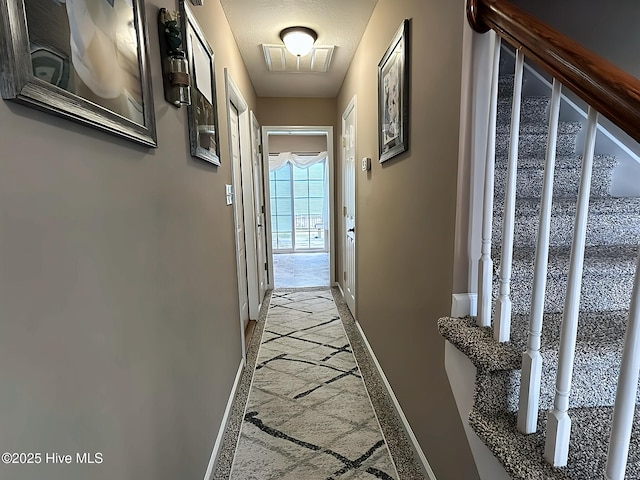 hallway with visible vents and baseboards