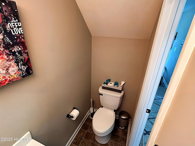bathroom with baseboards, tile patterned floors, and toilet