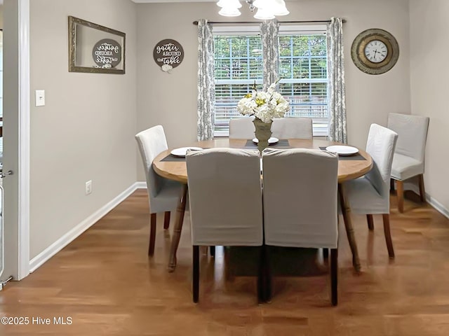 dining room featuring baseboards, wood finished floors, and a chandelier