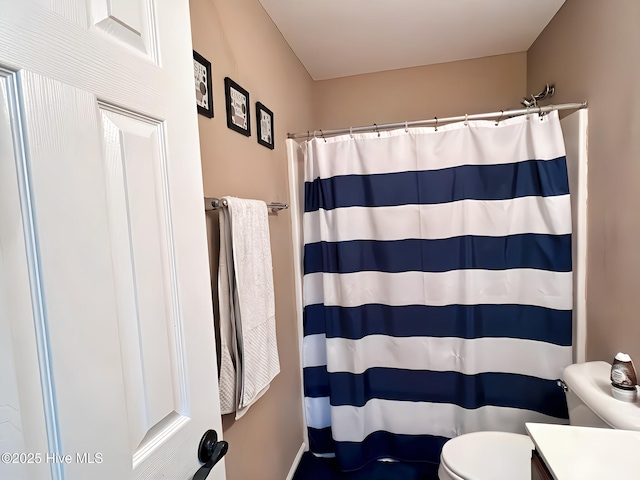 bathroom featuring vanity, toilet, and a shower with shower curtain