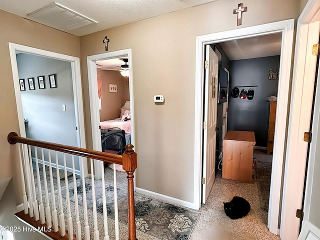 hallway featuring carpet floors, baseboards, and visible vents