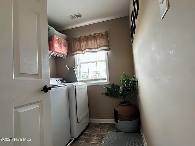 clothes washing area with baseboards, laundry area, visible vents, and washer and clothes dryer
