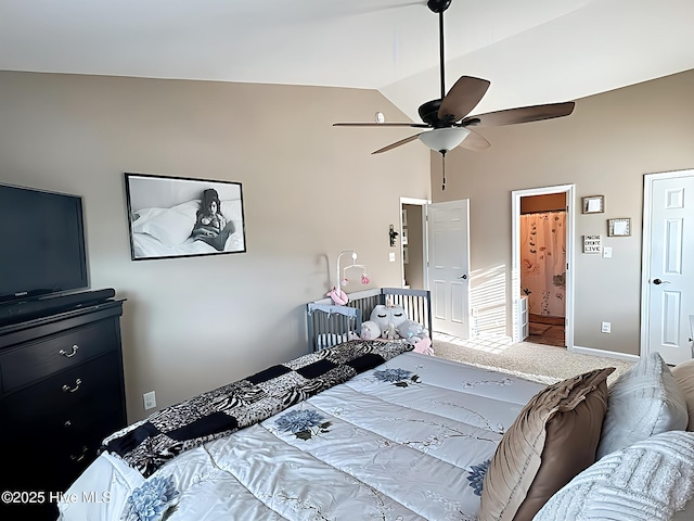 bedroom with carpet flooring, connected bathroom, a ceiling fan, baseboards, and vaulted ceiling