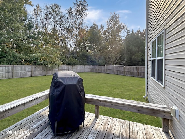 wooden terrace featuring a lawn, a fenced backyard, and grilling area