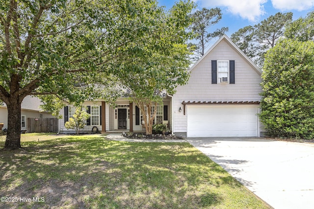 view of front of home with concrete driveway, fence, a front yard, and a garage