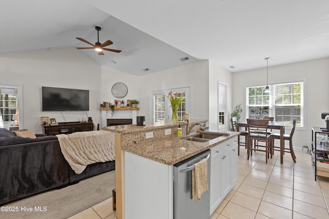 kitchen with a ceiling fan, open floor plan, light tile patterned floors, a sink, and dishwasher