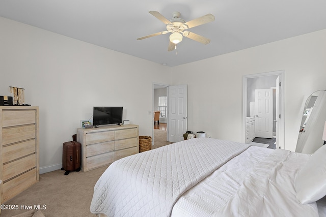 bedroom with baseboards, ceiling fan, connected bathroom, and light colored carpet