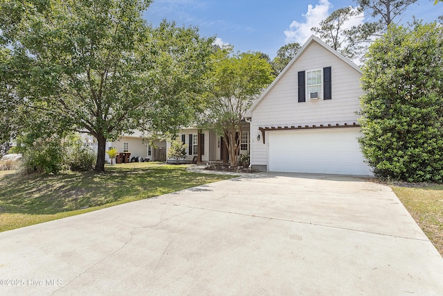traditional-style home with an attached garage, a front lawn, and driveway