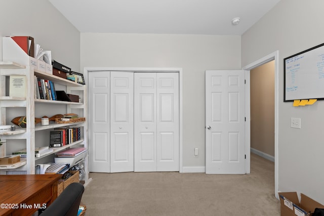 interior space featuring baseboards, a closet, and light carpet