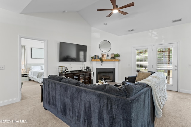 living room with visible vents, a fireplace, baseboards, light colored carpet, and vaulted ceiling