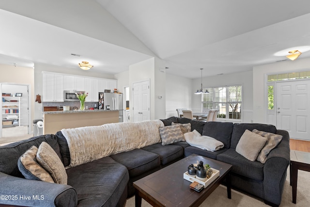living room with vaulted ceiling and visible vents