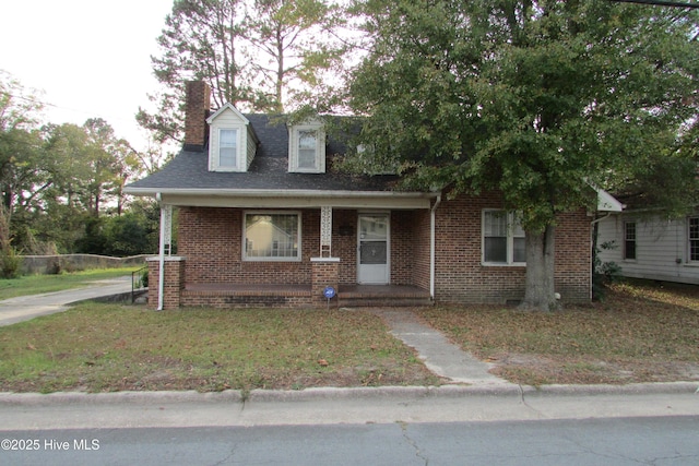 803 Mccoy St, Clinton, NC 28328 - cape cod home with a porch, brick siding, and a chimney