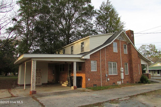 803 Mccoy St, Clinton, NC 28328 - view of property exterior with crawl space, a chimney, brick siding, concrete driveway, and an attached carport