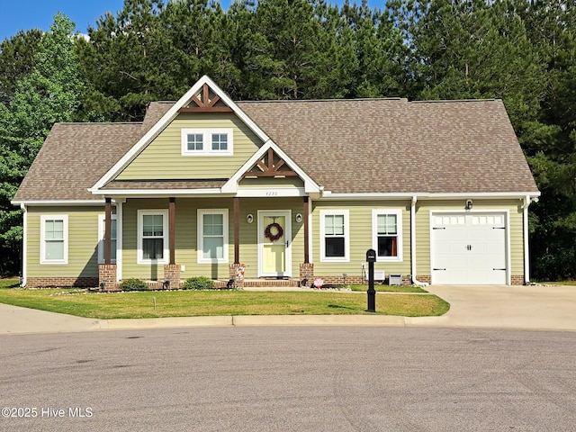 craftsman-style house featuring concrete driveway, roof with shingles, a garage, and a front lawn