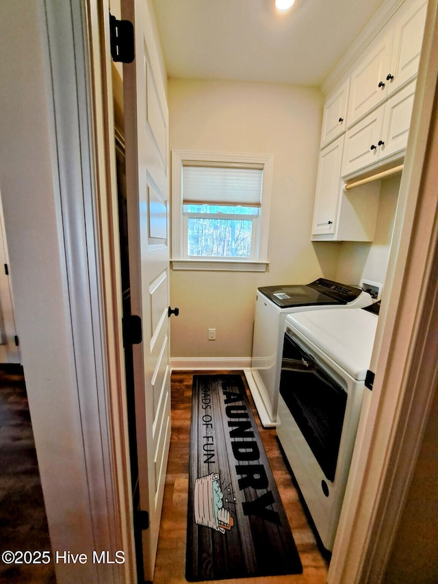 laundry room with baseboards, washing machine and dryer, cabinet space, and dark wood-type flooring