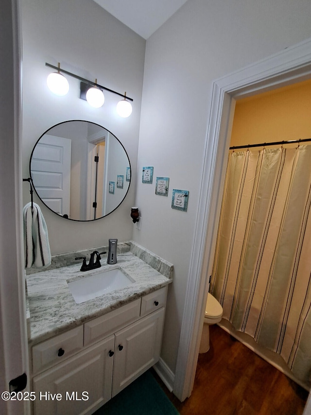 full bathroom featuring toilet, a shower with shower curtain, wood finished floors, and vanity