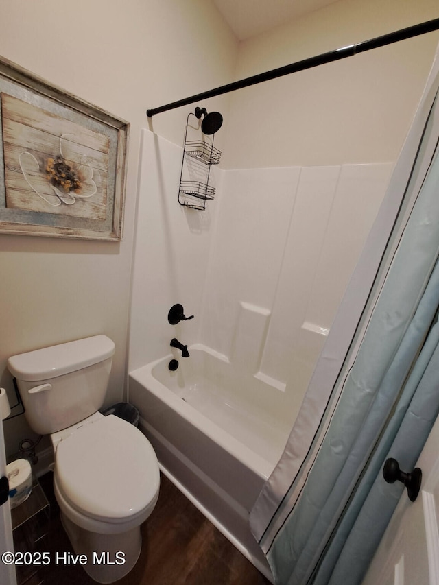 bathroom featuring toilet, shower / bath combo with shower curtain, and wood finished floors