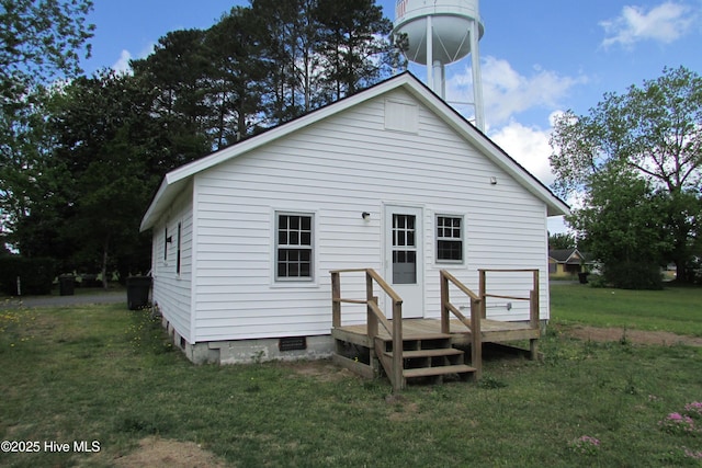 back of property featuring a lawn and a wooden deck