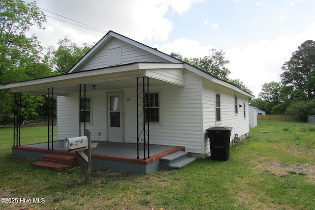 back of house with a porch and a yard