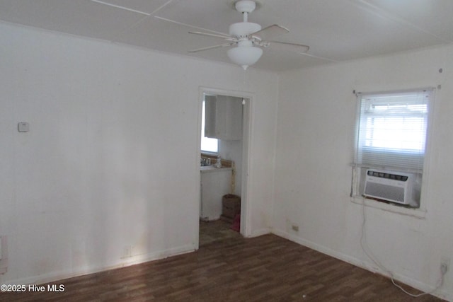 spare room with wood finished floors, baseboards, ceiling fan, and cooling unit