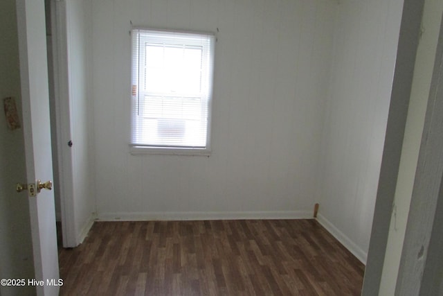 unfurnished room with dark wood-type flooring, baseboards, and a wealth of natural light