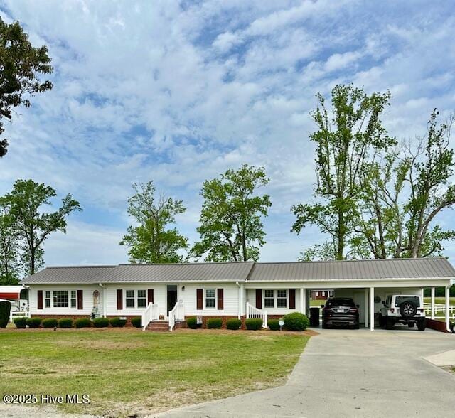 single story home featuring a front lawn, driveway, an attached carport, and metal roof