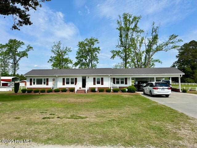 single story home featuring a carport, driveway, and a front yard