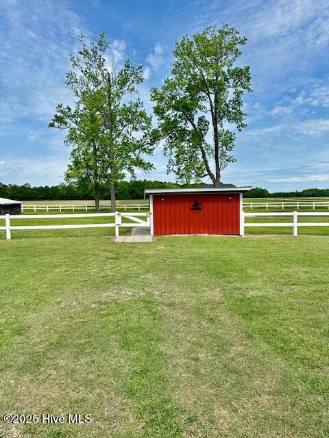 view of shed featuring fence and a rural view