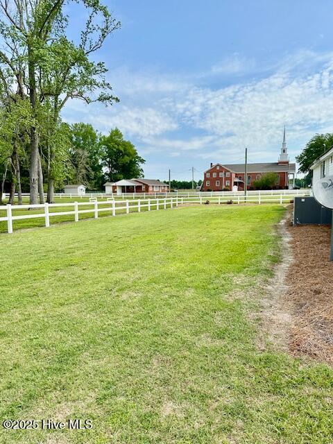 view of yard with fence and a rural view