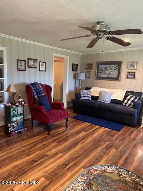 living area featuring crown molding, ceiling fan, and wood finished floors
