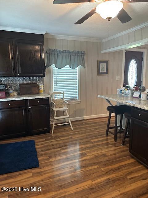 dining area featuring crown molding, ceiling fan, and dark wood-style floors