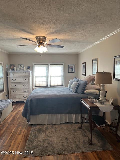 bedroom with a textured ceiling, dark wood finished floors, and multiple windows