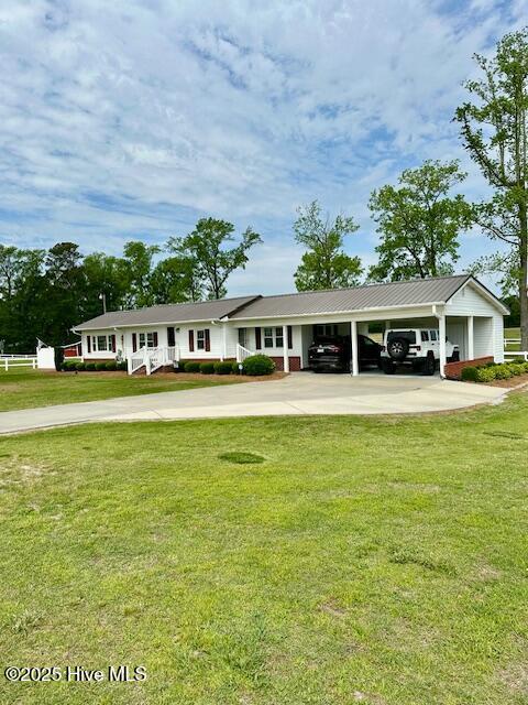 exterior space with a carport, a yard, and concrete driveway