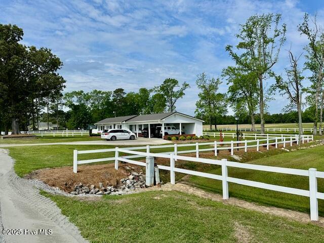 exterior space with a rural view, driveway, and fence private yard