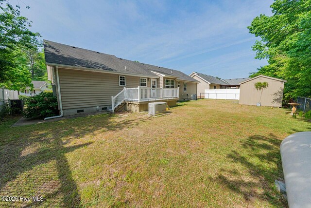146 Ranch Dr, Elizabeth City, NC 27909 - back of property with crawl space, a storage shed, a deck, an outbuilding, and fence