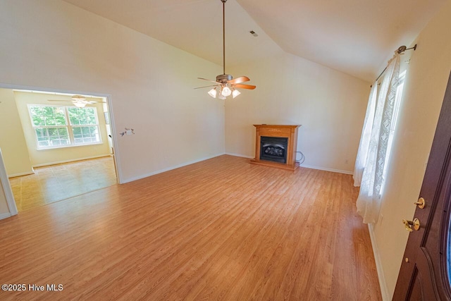 146 Ranch Dr, Elizabeth City, NC 27909 - unfurnished living room featuring a fireplace with raised hearth, light wood-style flooring, a ceiling fan, baseboards, and lofted ceiling