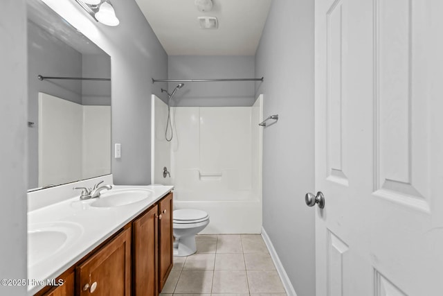 bathroom with a sink, tile patterned flooring, double vanity, toilet, and baseboards