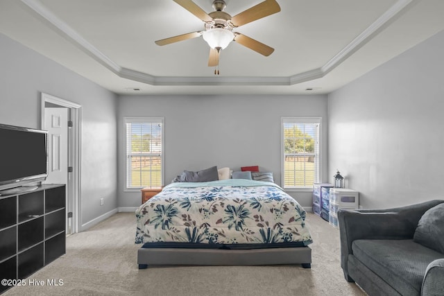 carpeted bedroom featuring a raised ceiling, ornamental molding, baseboards, and a ceiling fan
