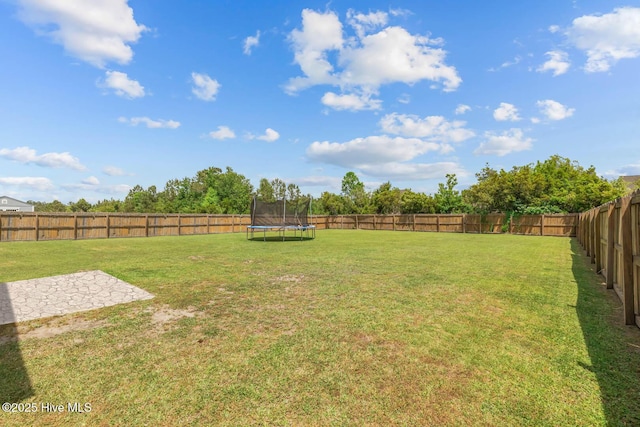 view of yard featuring a fenced backyard and a trampoline