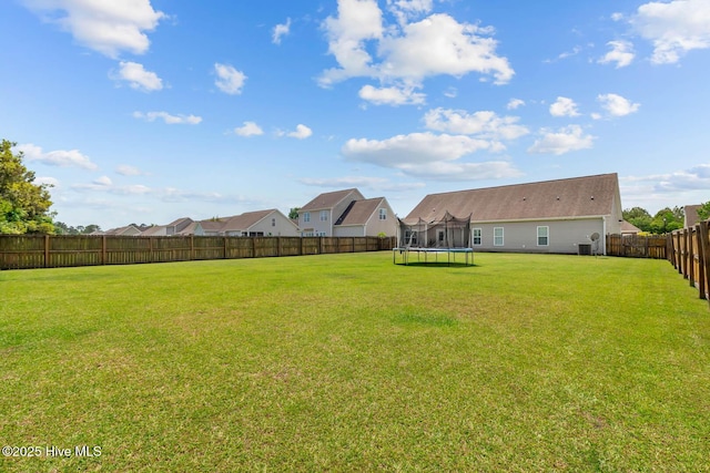 view of yard with a fenced backyard and a trampoline