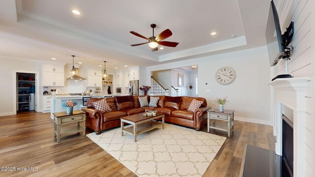 105 Camden Trl, Hampstead, NC 28443 - living area with a tray ceiling, stairs, ceiling fan, recessed lighting, and light wood finished floors