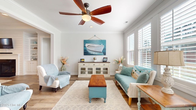 105 Camden Trl, Hampstead, NC 28443 - living room featuring a ceiling fan, wood finished floors, a glass covered fireplace, ornamental molding, and baseboards
