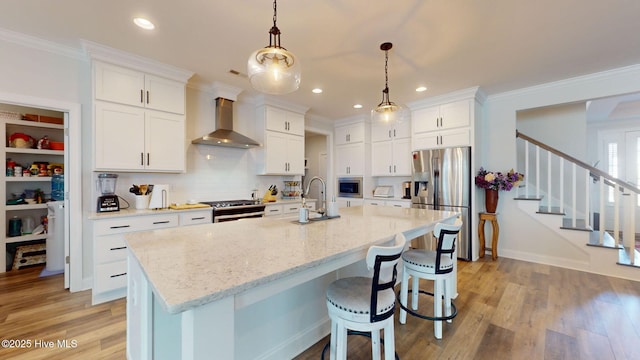 105 Camden Trl, Hampstead, NC 28443 - kitchen with wall chimney range hood, stainless steel appliances, a sink, white cabinets, and light wood-type flooring